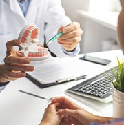 Dentist showing patient model of teeth