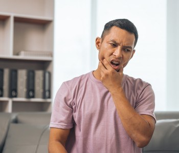 Man experiencing toothache on couch in office