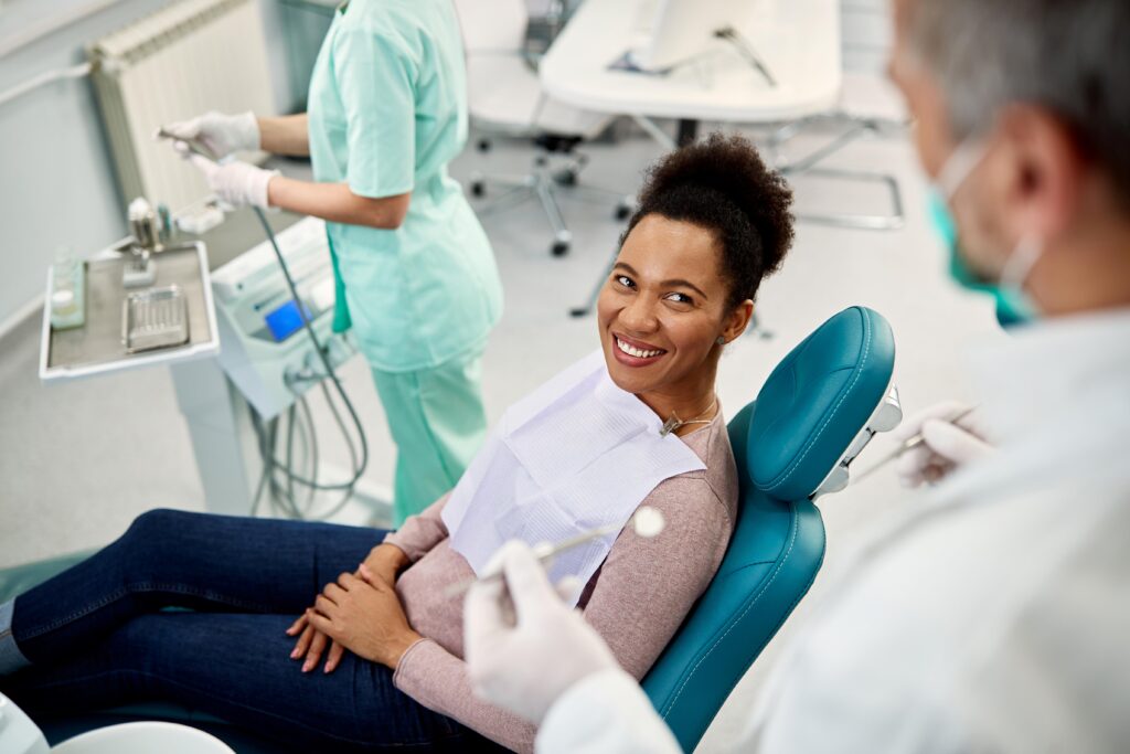 Woman smiling while talking to dentist in treatment chair